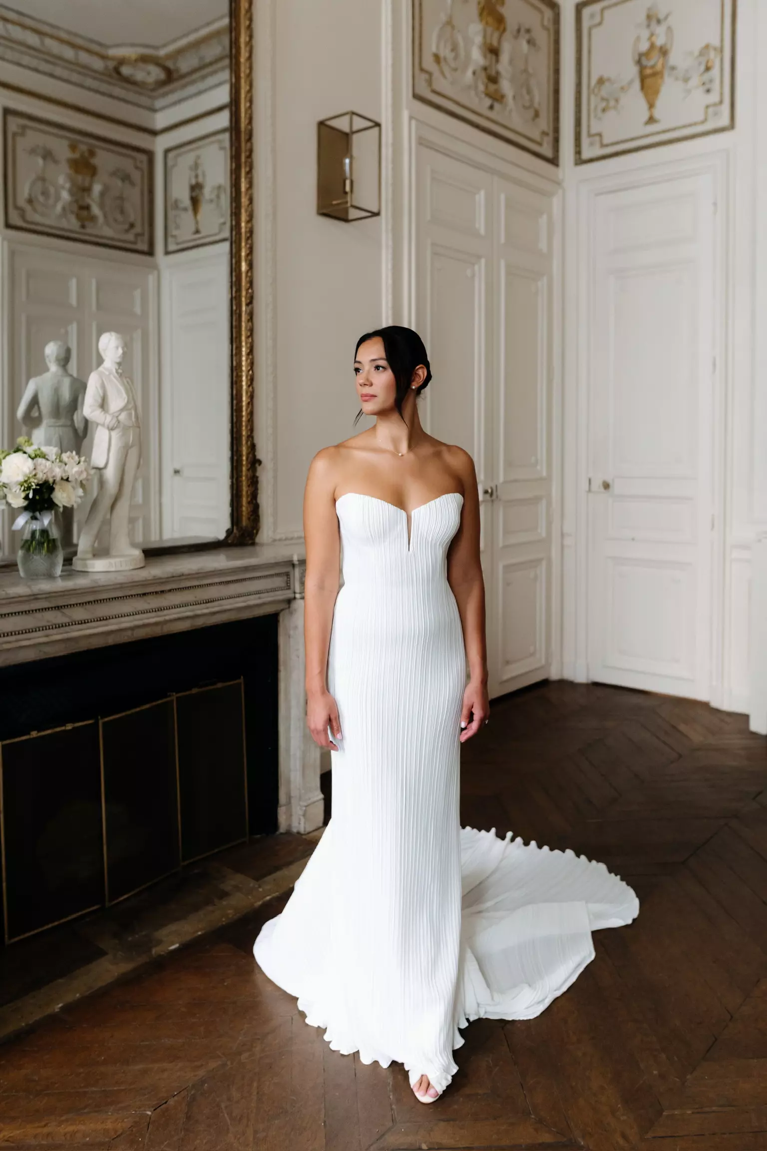 Bride Erin in structured wedding gown with sleek low bun and luminous bridal makeup created in Paris