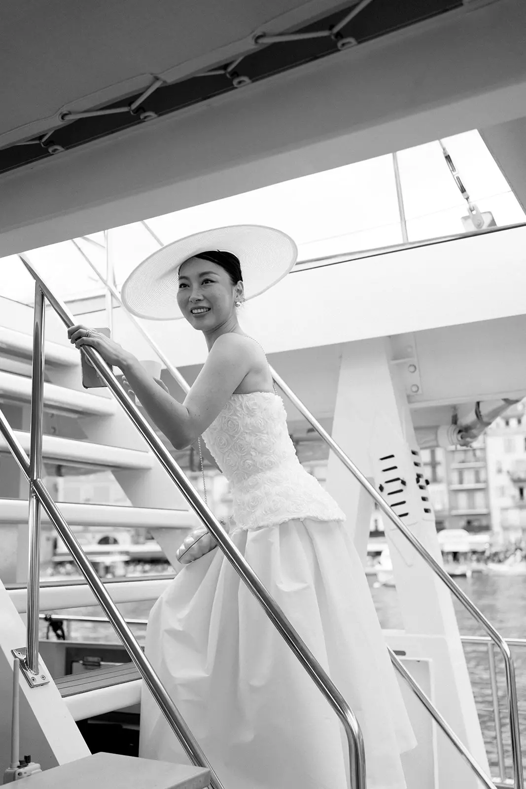 Bride boarding yacht showcasing sleek bridal hairstyle and luminous complexion finish