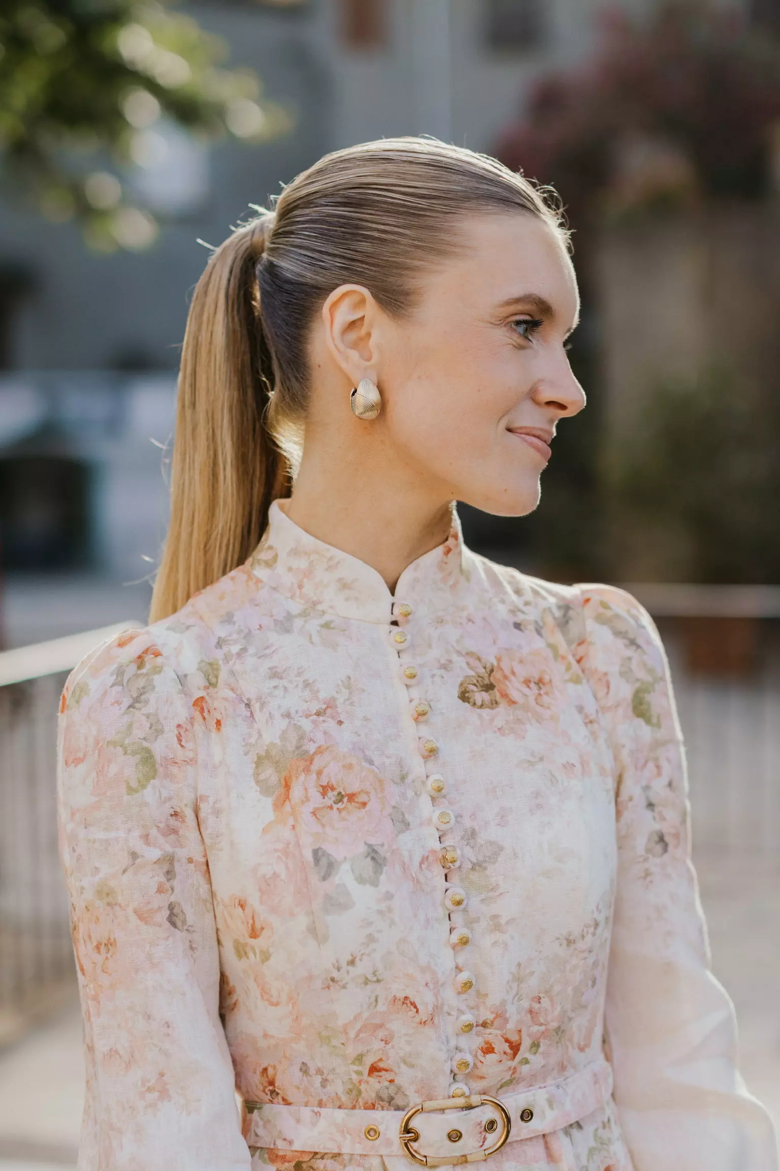 Bride Sophie in floral dress with polished ponytail hairstyle during family celebration in Corsica