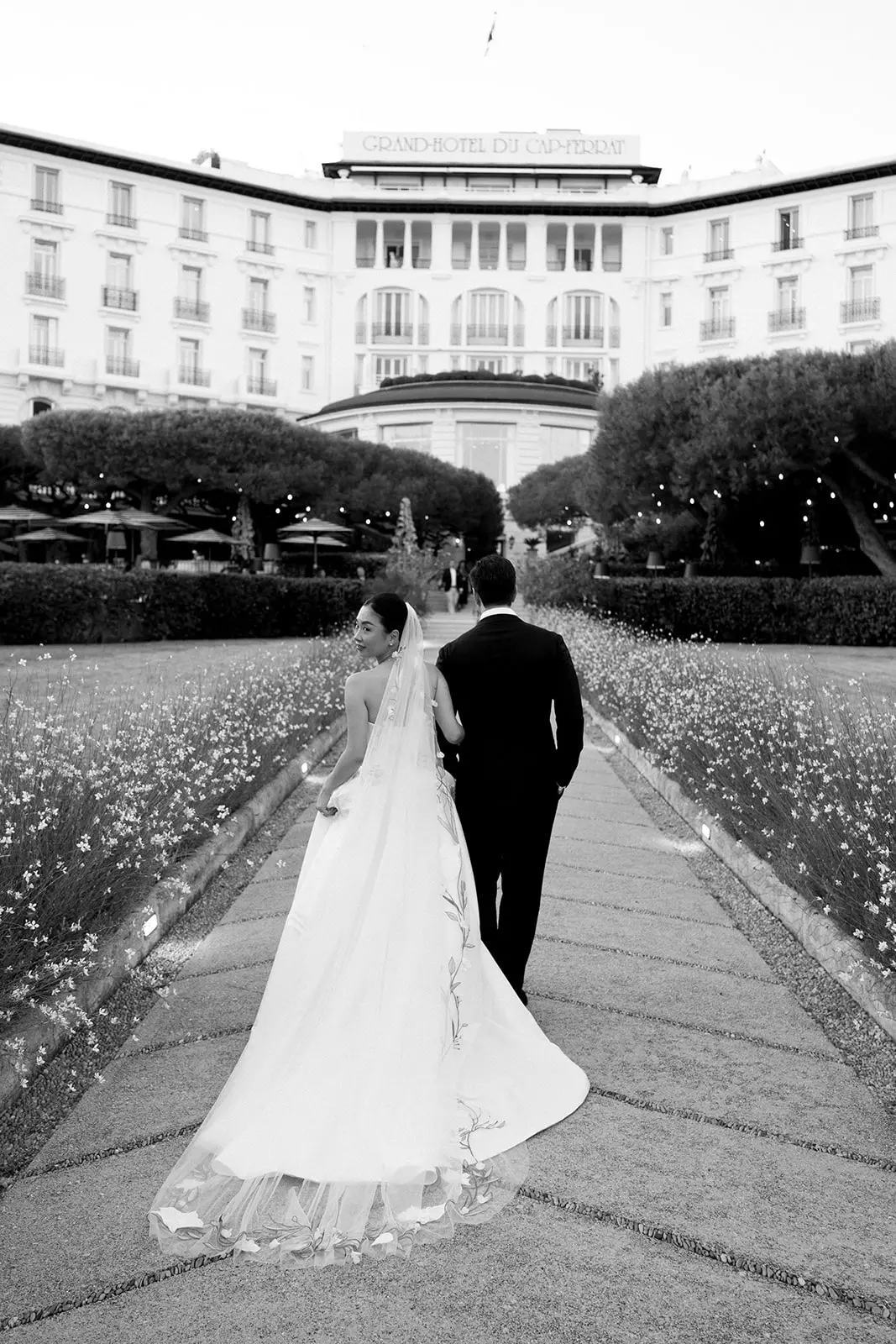 Bride and groom walking through garden at Four Seasons with polished bridal styling by Mandy Dorian