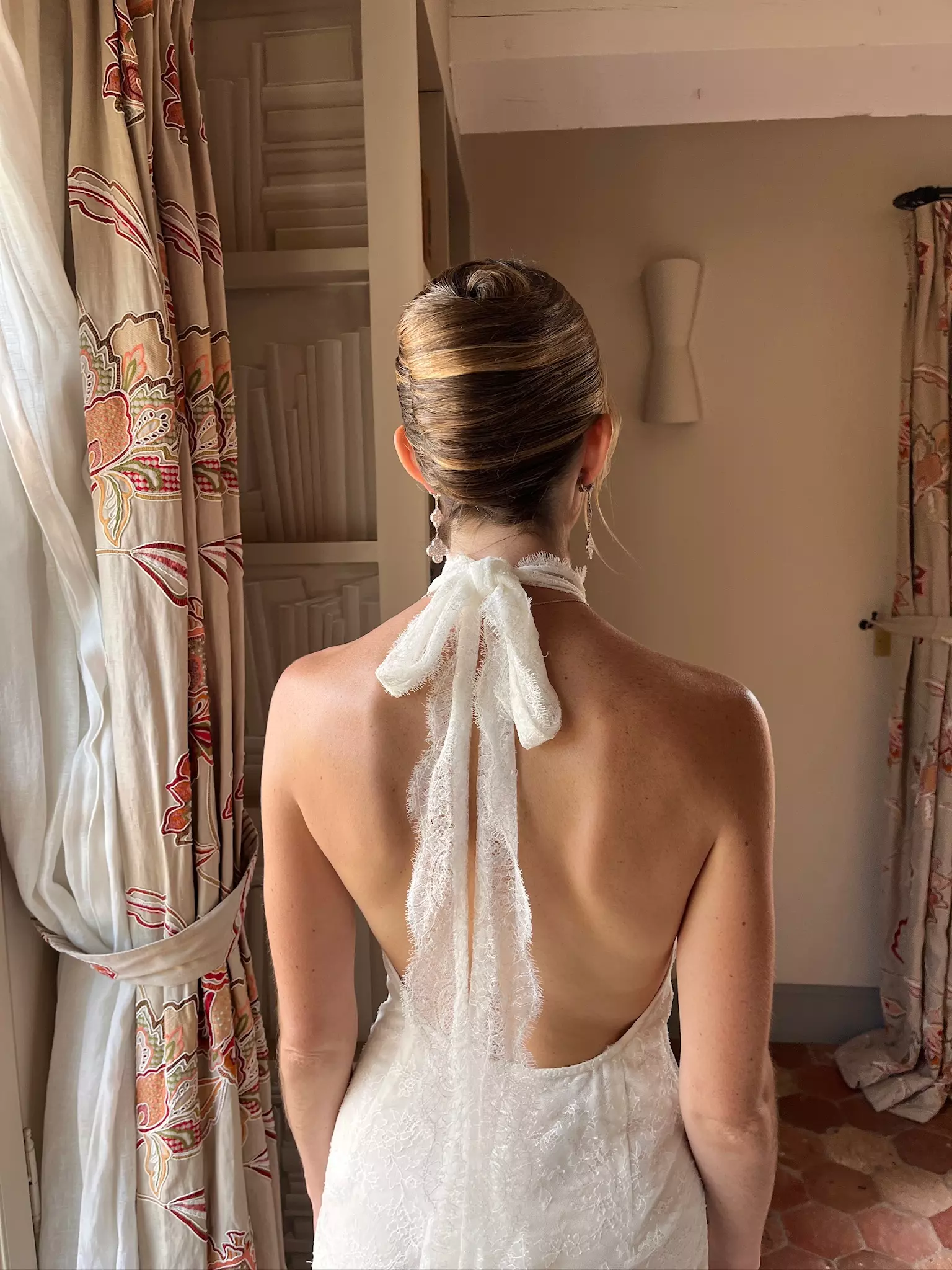 Back view of bride showcasing refined low bun bridal hairstyle by Mandy Dorian at Château de Berne
