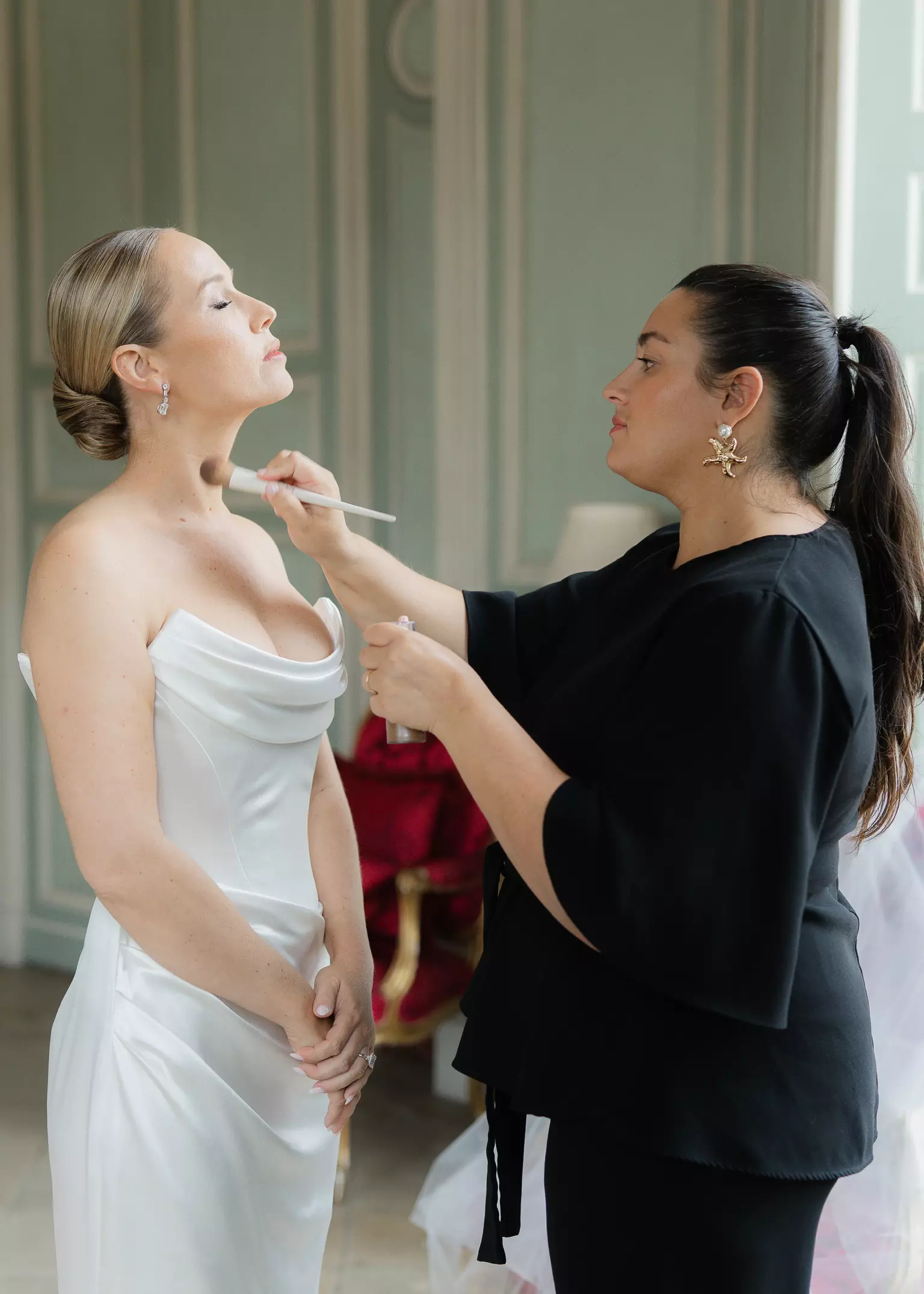 Mandy Dorian applying final makeup touch up on bride during luxury wedding day in Paris