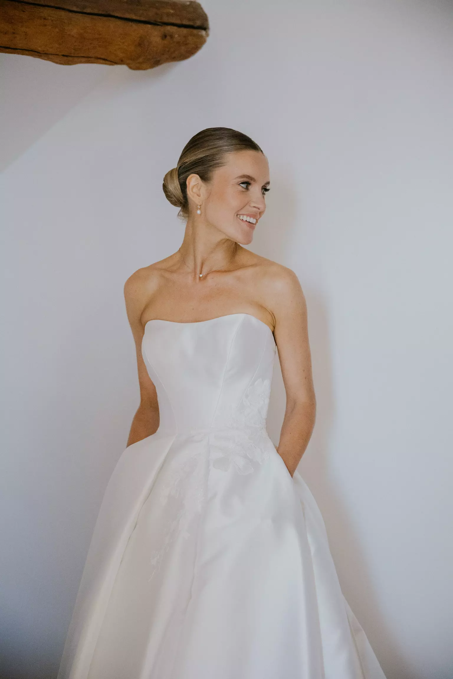 Bride Sophie wearing strapless gown with refined bridal bun and natural radiant makeup in Corsica