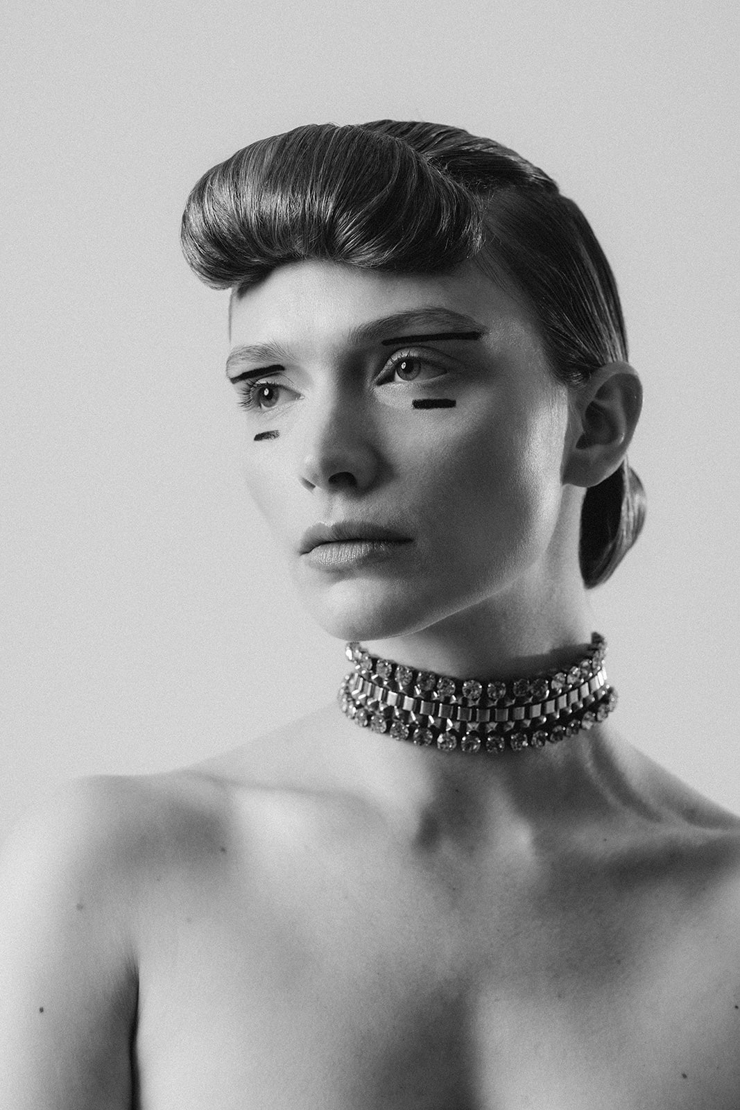 Close up portrait emphasizing defined eye makeup and sleek architectural hairstyle by Mandy Dorian