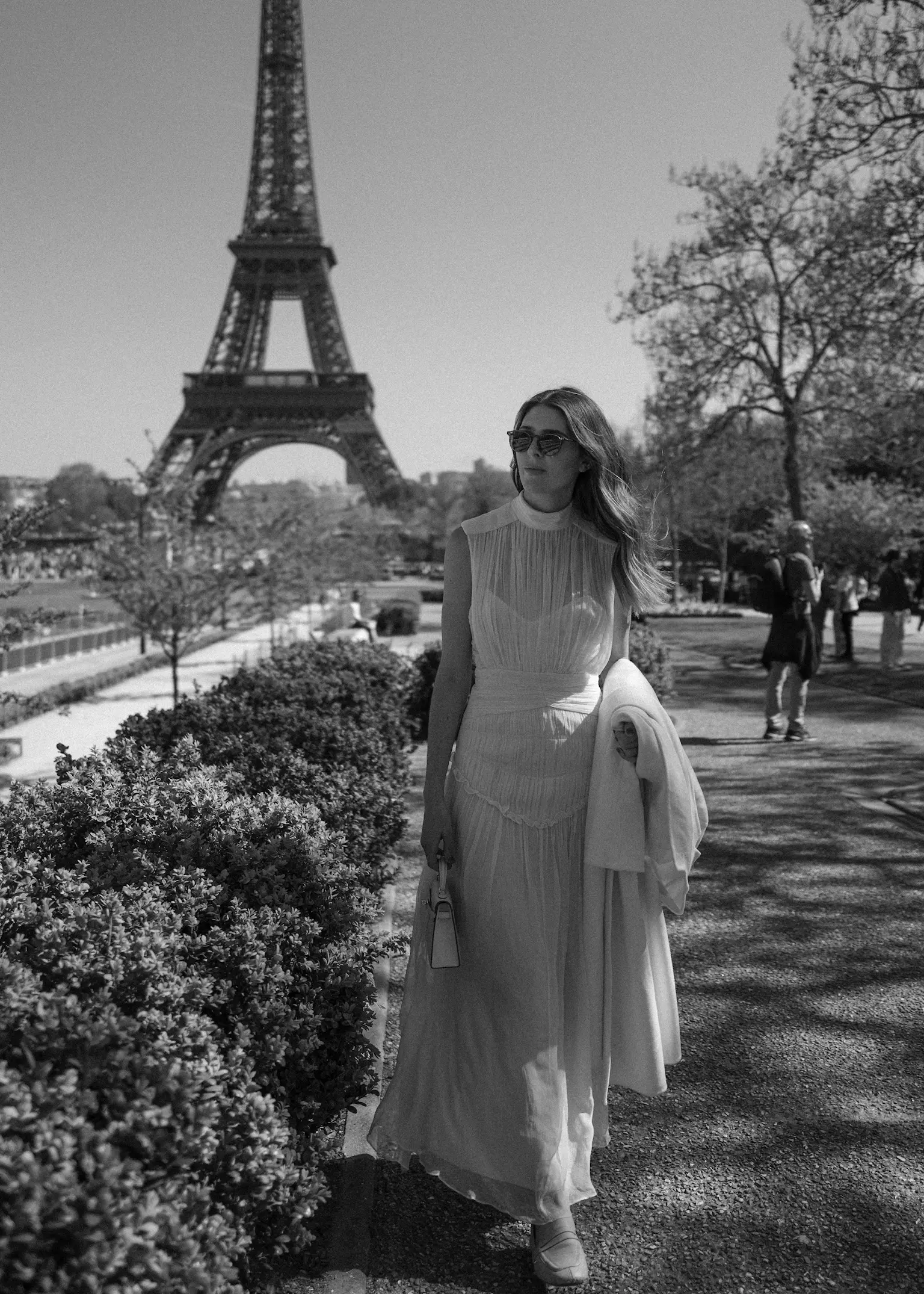 Bride walking near Eiffel Tower showcasing refined bridal hairstyle and polished makeup during Paris bridal trial