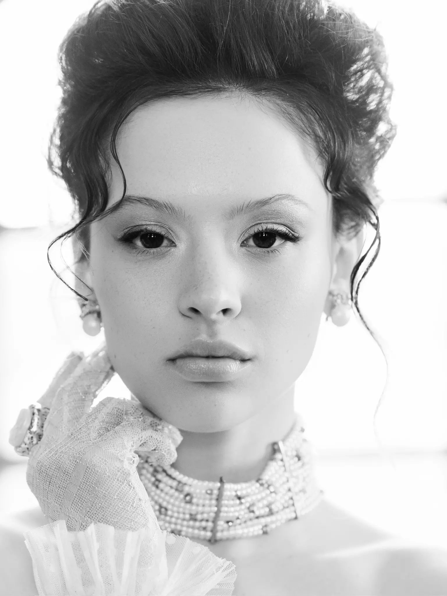 Black and white close up of bride highlighting calm refined bridal makeup and structured hairstyle