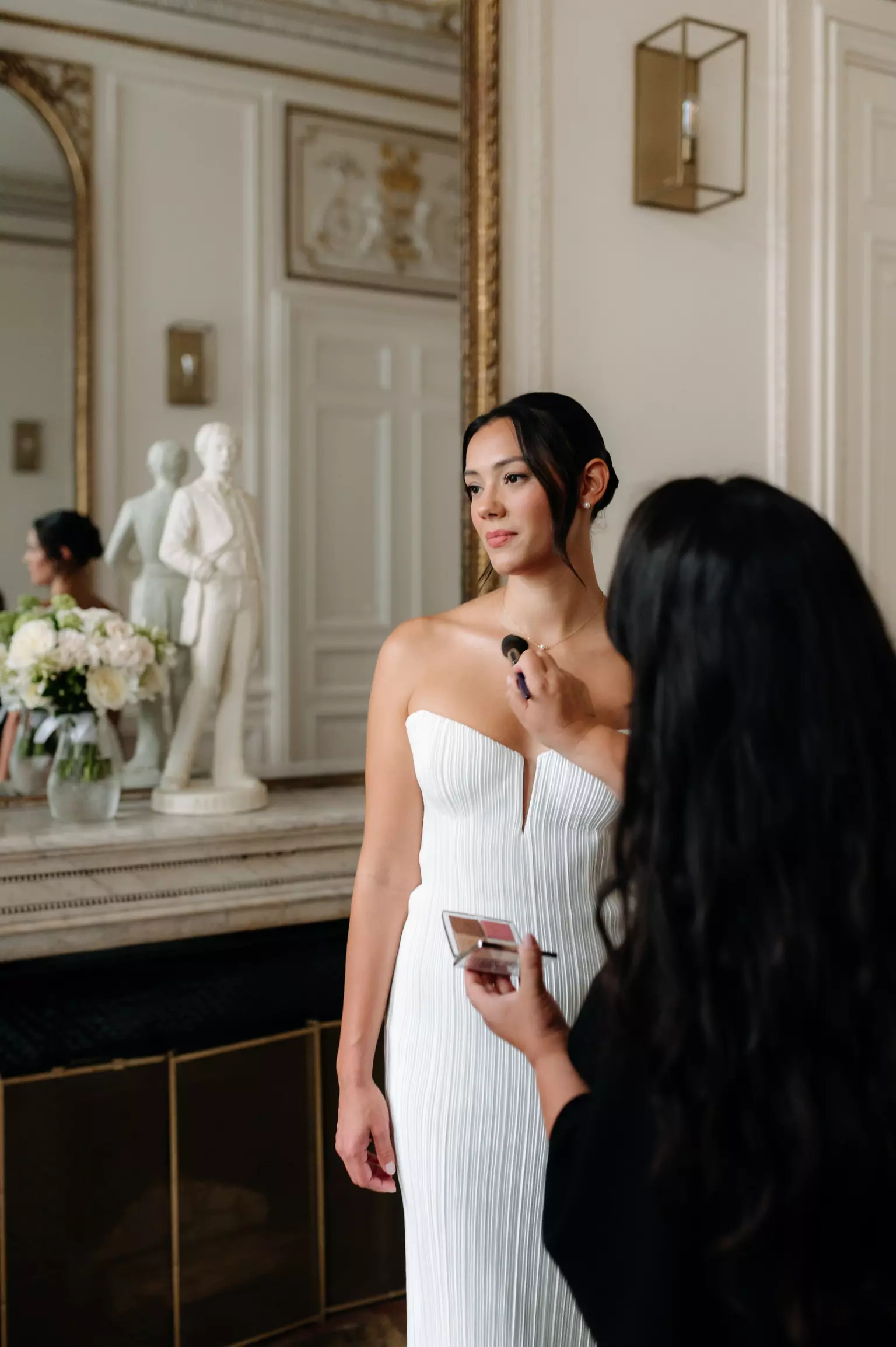 Close up of Mandy Dorian applying finishing touches to bride’s makeup at Hôtel Alfred Sommier