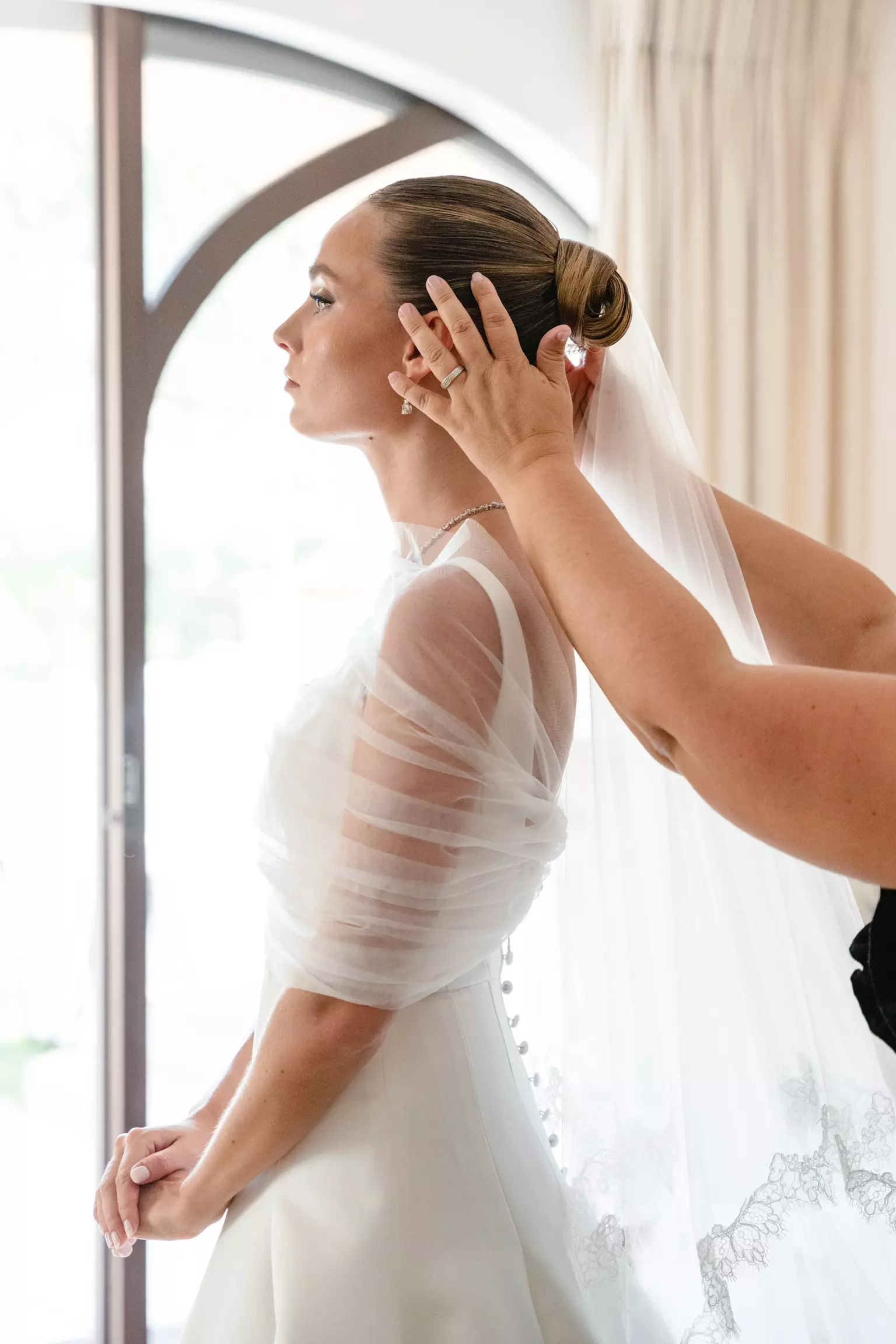 Mandy Dorian adjusting bride’s hairstyle ensuring flawless bridal look before ceremony