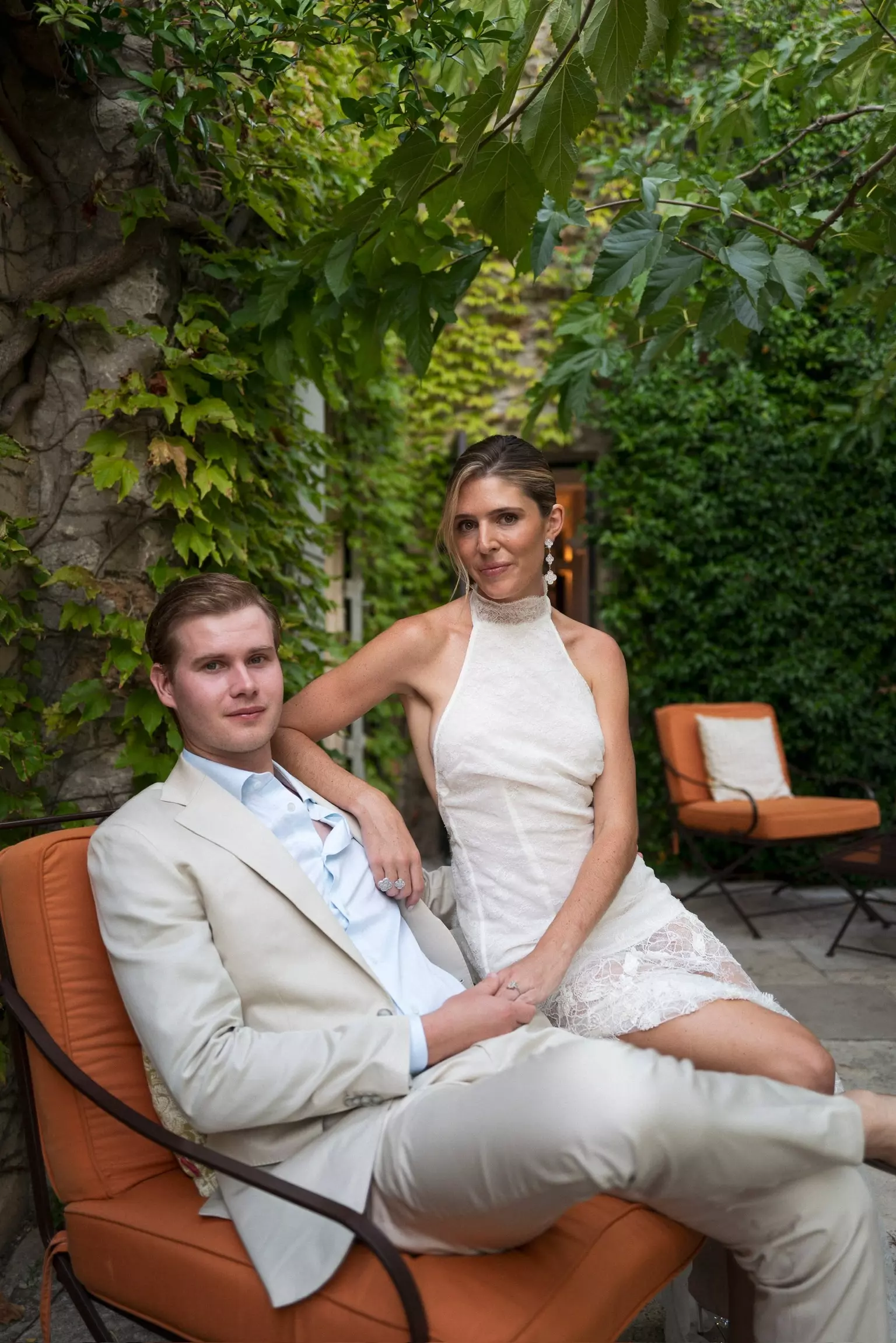 Bride and groom seated outdoors with polished bridal hair and makeup created for wedding weekend in Provence