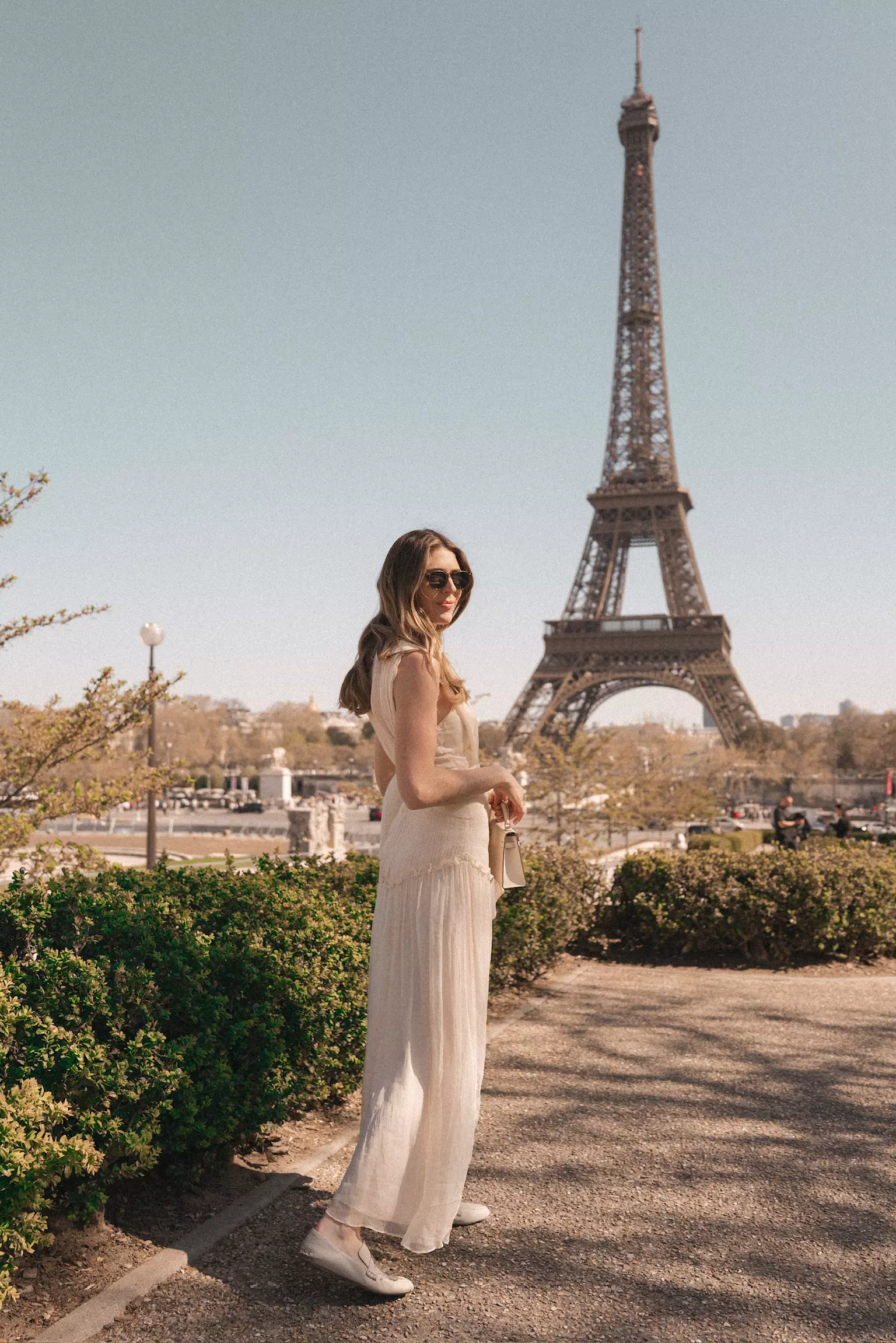 Bride standing near Eiffel Tower with effortless bridal hairstyle and luminous makeup created in Paris