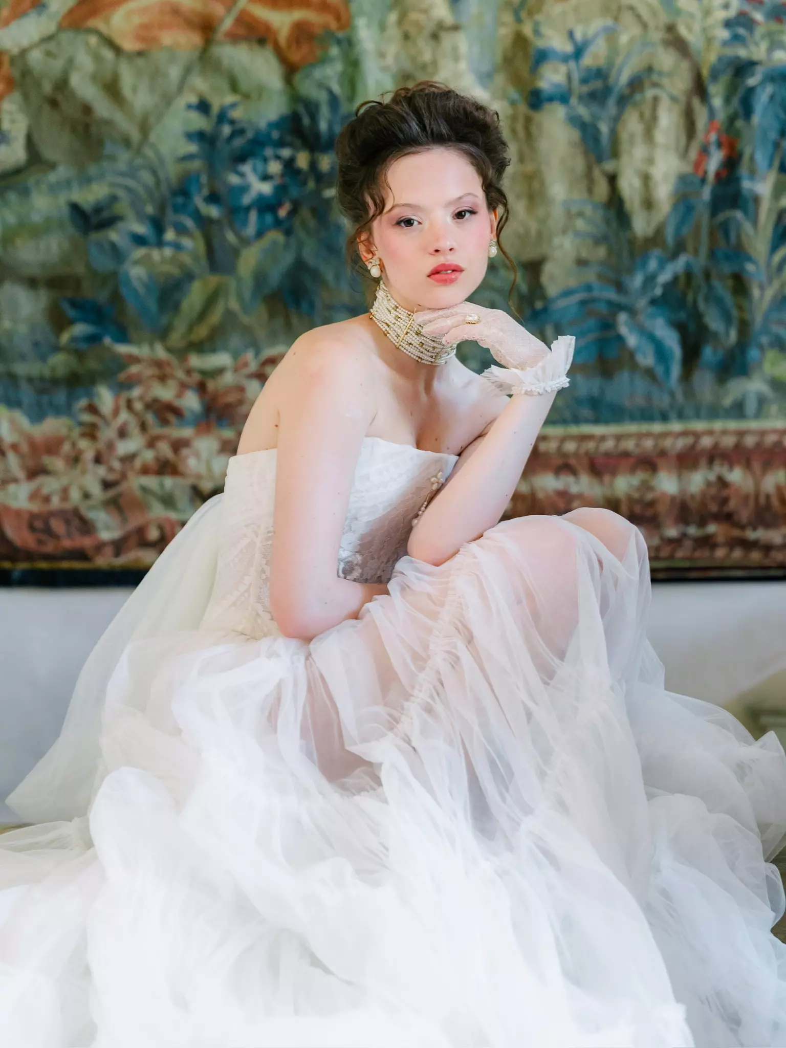 Bride seated in layered tulle gown with intentional bridal beauty styling by Mandy Dorian