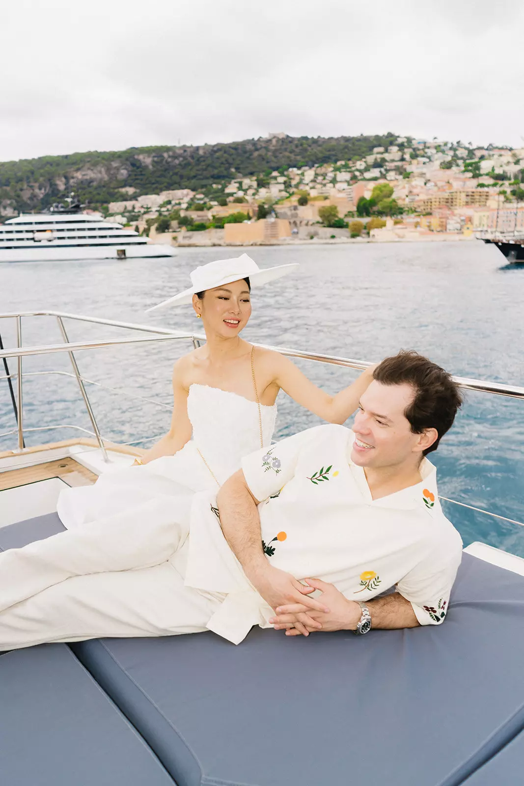 Bride and groom relaxing on yacht with refined bridal hair and makeup designed to enhance natural beauty
