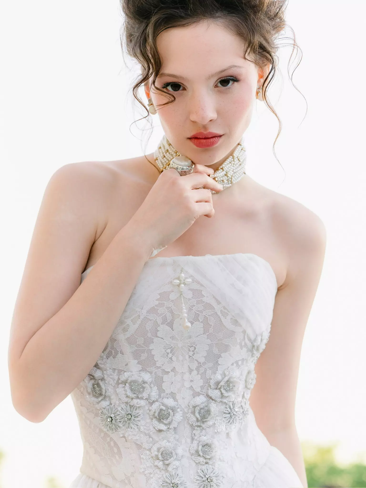 Bride in strapless couture gown with soft sculpted bridal hairstyle and luminous makeup