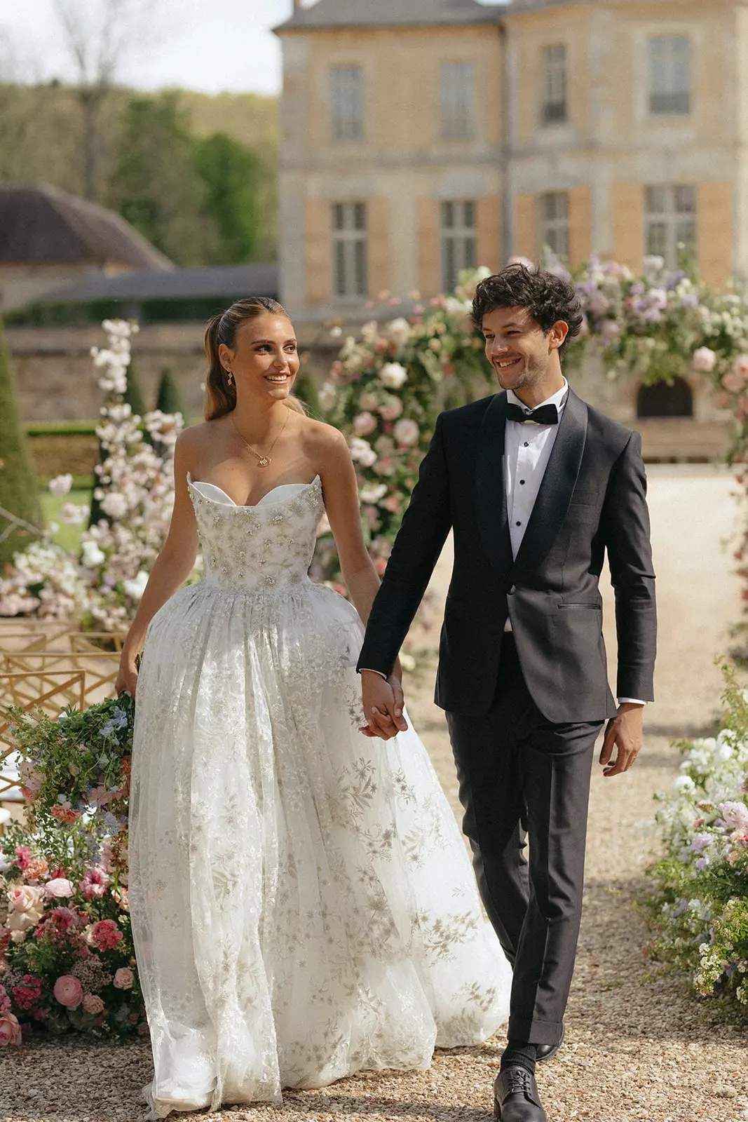 Bride and groom walking hand in hand with polished bridal beauty by Mandy Dorian