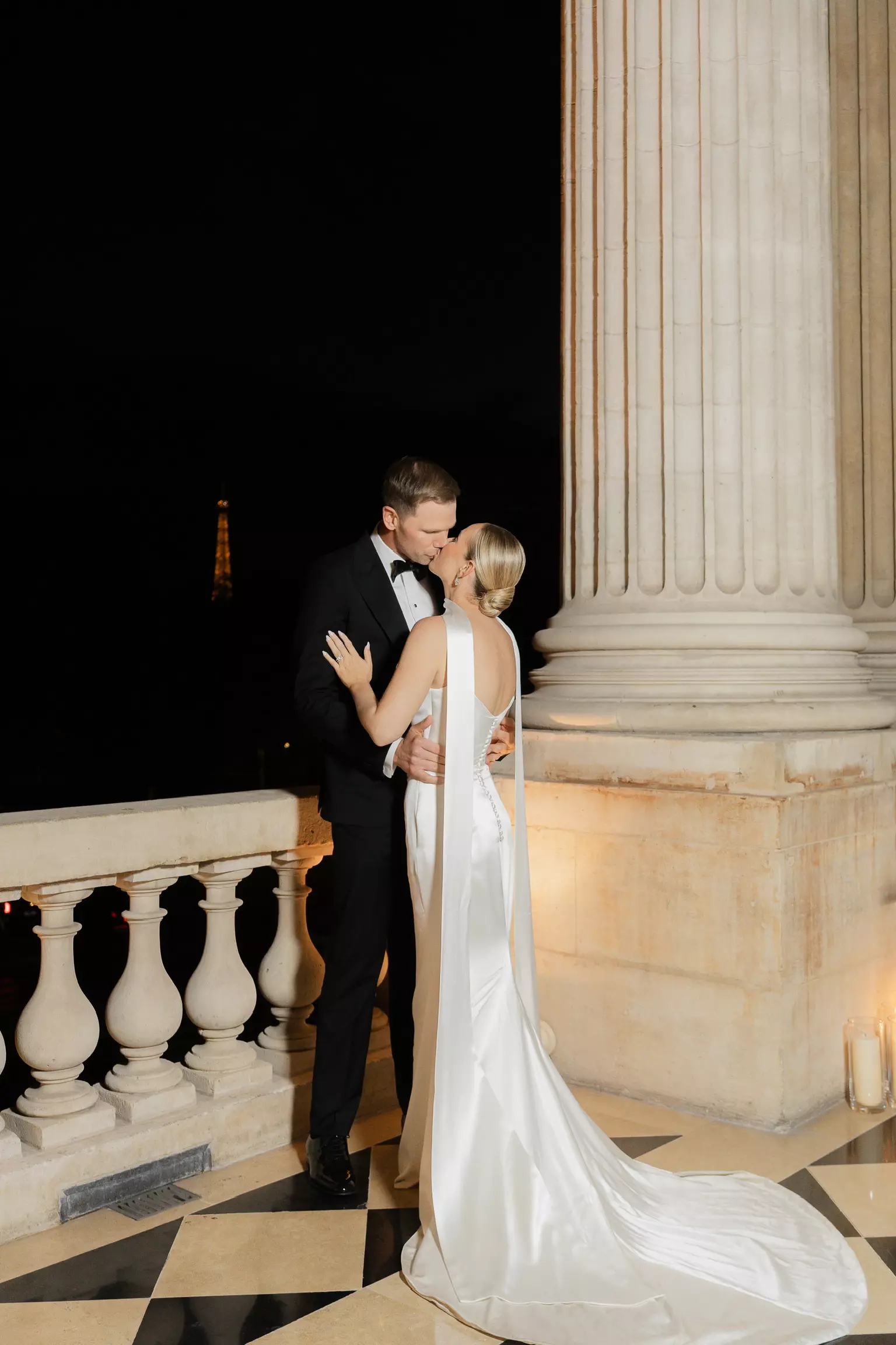 Bride embraced by groom at night showcasing polished bridal hair and makeup designed to last all day