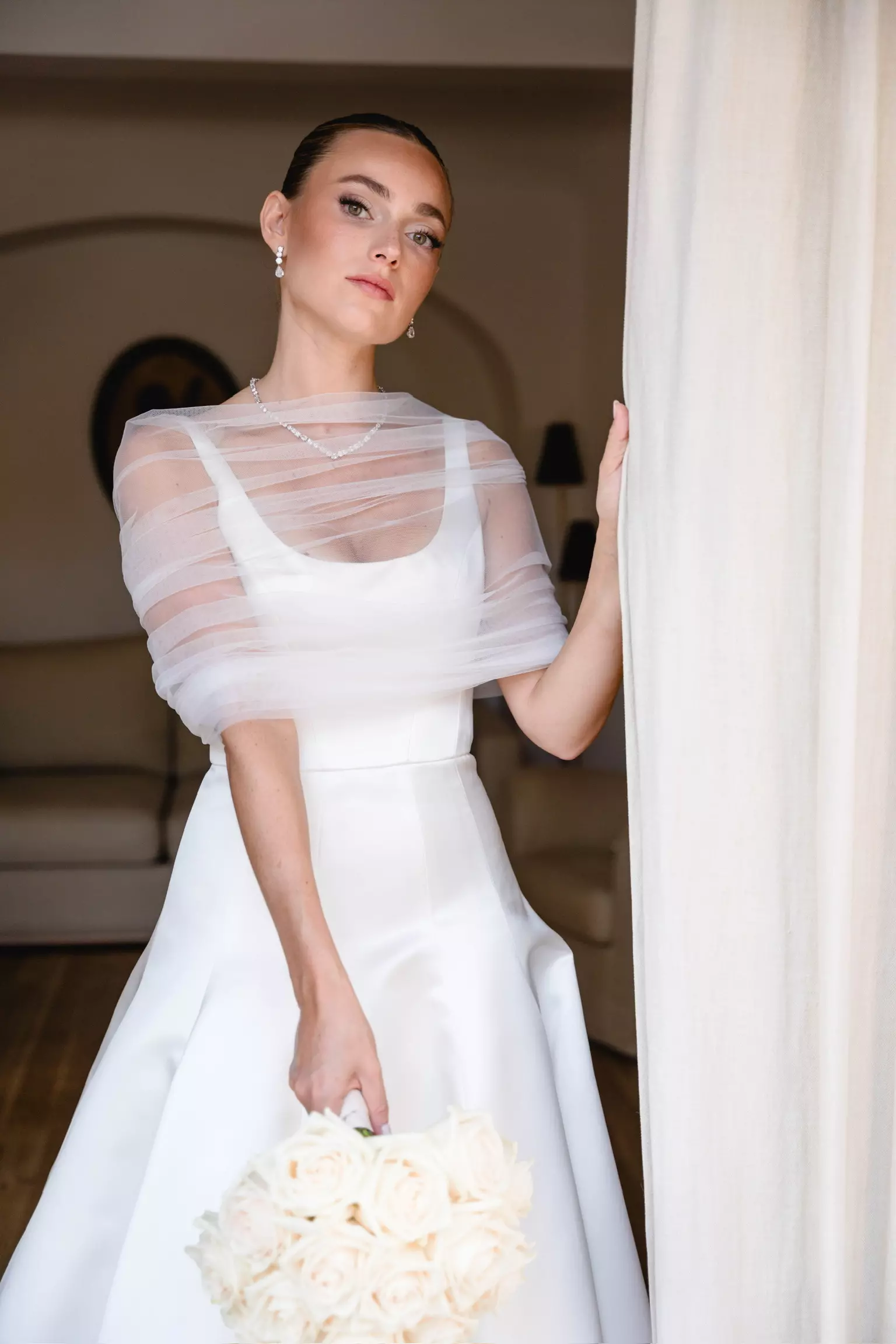 Bride wearing sheer structured gown with polished bridal hair and luminous makeup by Mandy Dorian