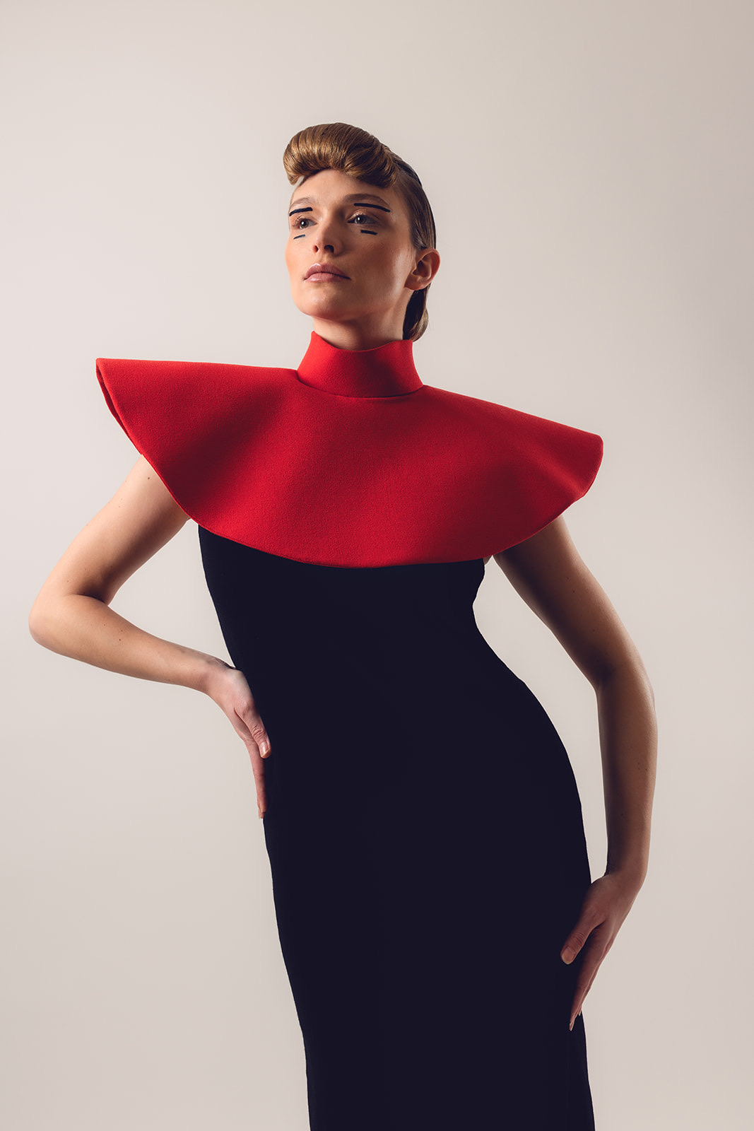 Full length portrait of model in Pierre Cardin dress with graphic makeup and sleek hairstyle