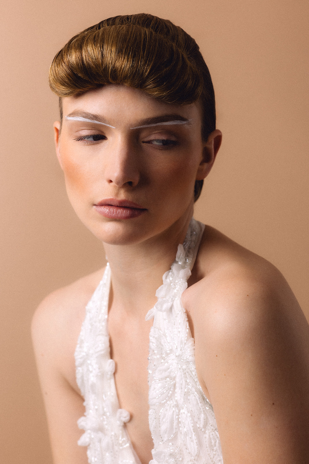 Model wearing halter neckline with sculpted graphic makeup and structured hairstyle by Mandy Dorian for Pierre Cardin editorial