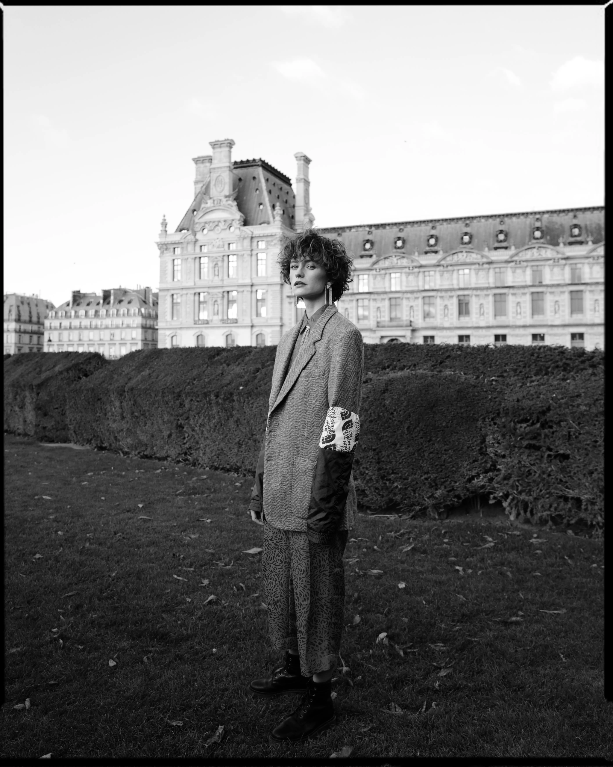 Model standing near Louvre in Paris featuring refined editorial makeup and sleek hairstyle