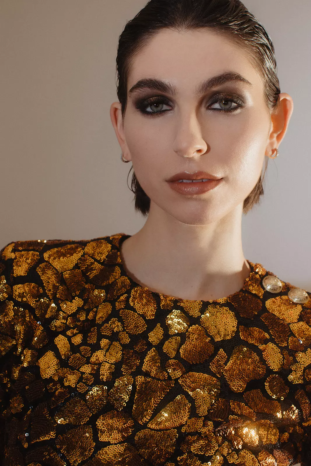 Model wearing textured gold top with sculpted eye makeup and luminous complexion by Mandy Dorian
