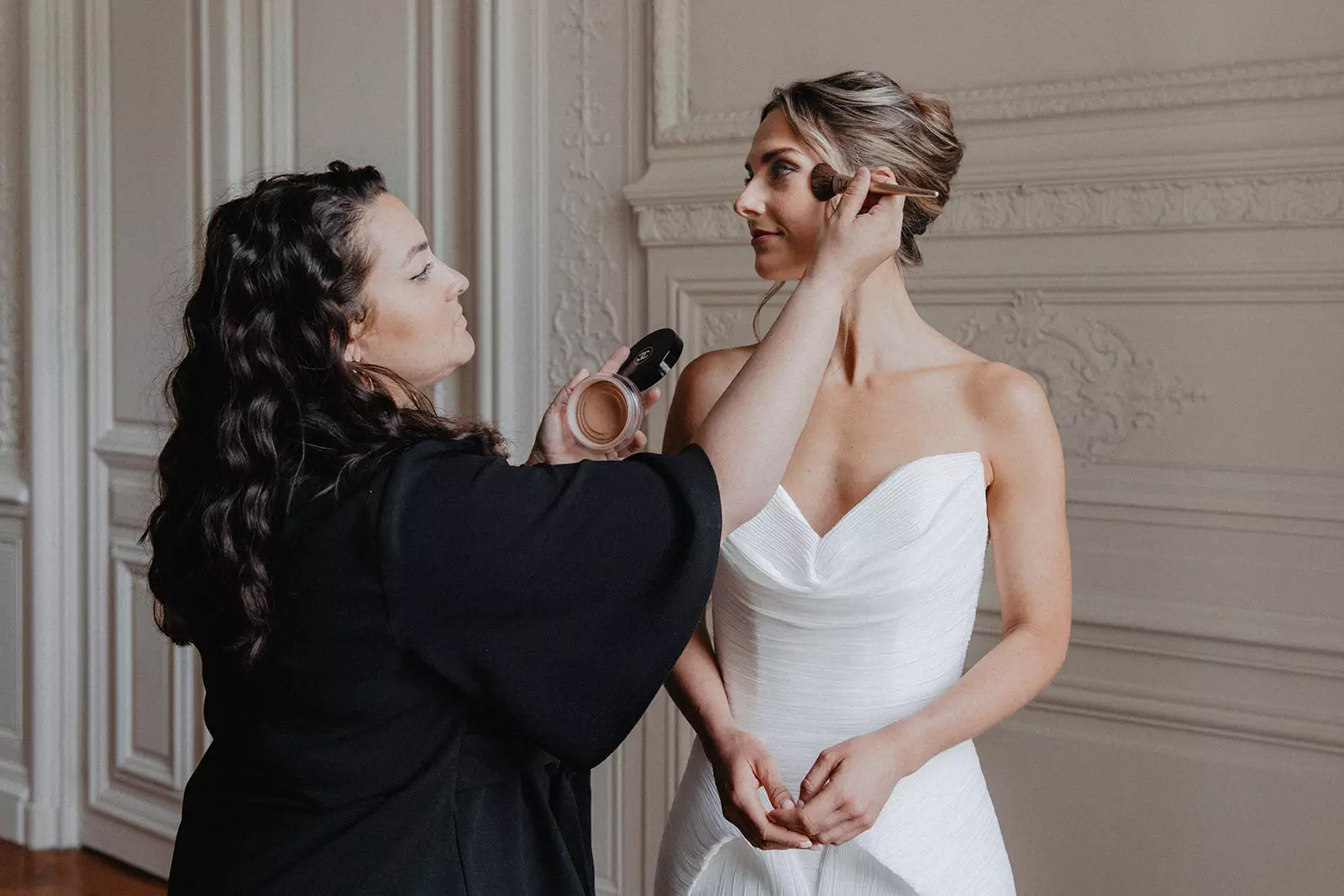 Mandy Dorian applying finishing touches to bride before ceremony in elegant venue